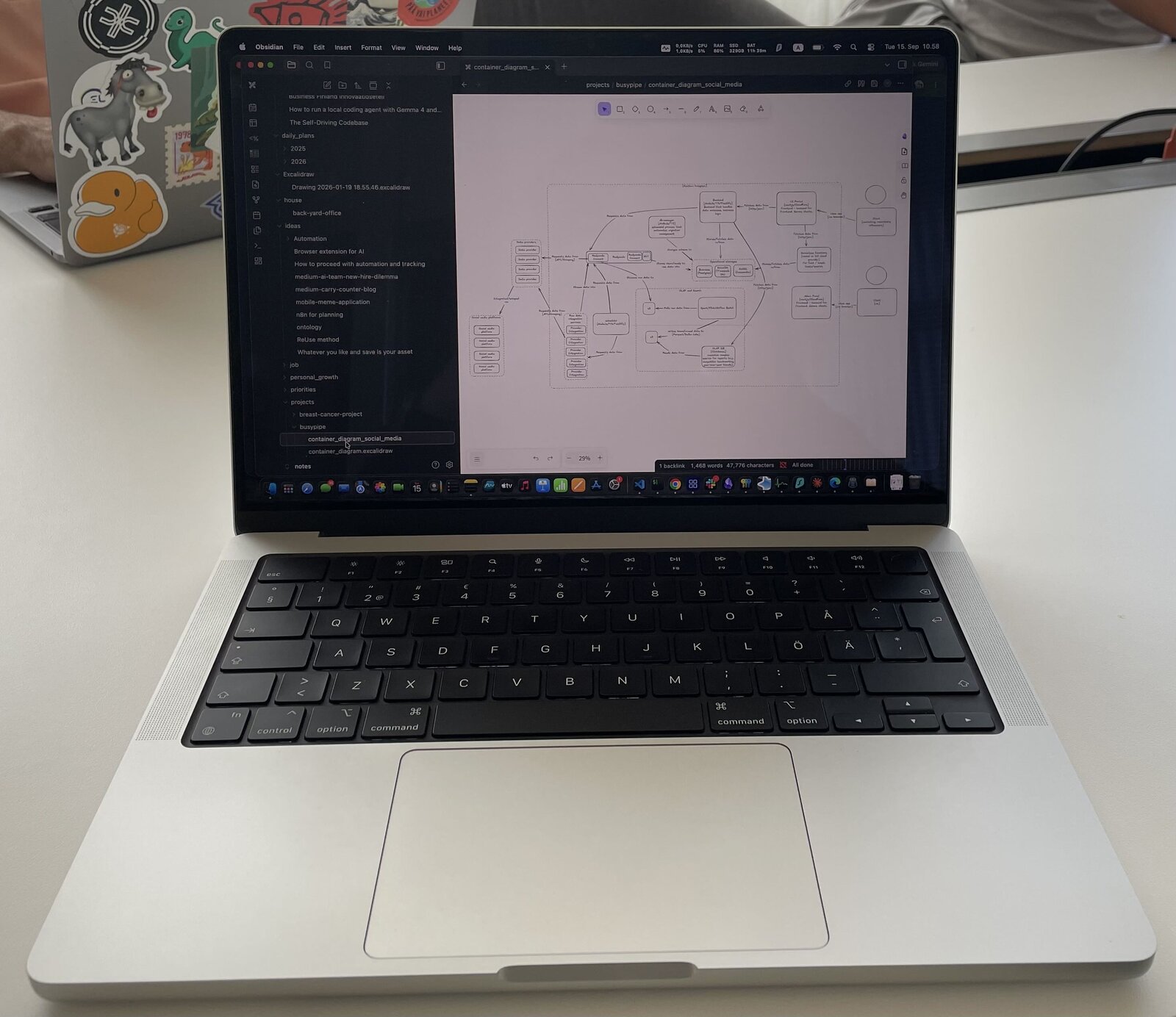 A laptop on a desk showing a software architecture diagram